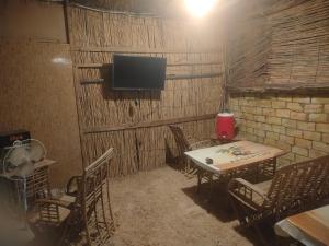 a room with a table and chairs and a television at agyptus camp in Siwa
