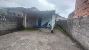 a building with a hammock next to a wall at Casa de temporada in Caraguatatuba +4 photos