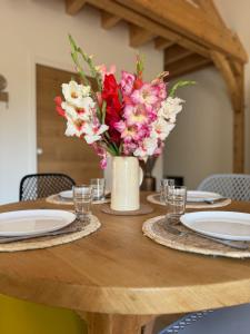 a vase of flowers sitting on top of a wooden table at Gîte La petite Reine de l Ouche in Sainte-Marie-sur-Ouche