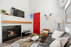a living room with a fireplace and a red door at Quarry A28 in Whitefish