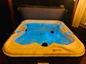a yellow bath tub with blue water in it at Manchaca 4 bedroom sleeps 10 Pool and Hot tub in Manchaca
