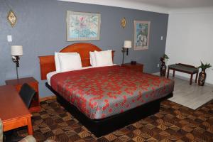 a bedroom with a large bed with a red bedspread at Best Nights Inn - Sparta in Sparta