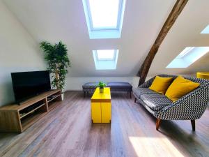 Una sala de estar con un sofá y un televisor. en L'appartement tranquillité, en Elbeuf