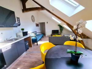 cocina y sala de estar con mesa y sillas amarillas en L'appartement tranquillité, en Elbeuf