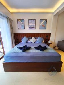 a bedroom with a large bed with blue sheets at Makadal'Eau Boutique Resort in Siquijor +19 photos