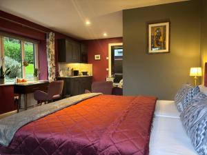a bedroom with a large bed and a kitchen at Stoneywood Haven, Galway in Clarinbridge