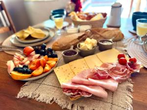 a table with a sandwich and fruits and cheese at Le Coin Tranquille in La Roque-Gageac