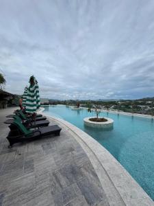 a person sitting in a chair in front of a swimming pool at Condo sea view rawai beach by phuket sweet home in Rawai Beach