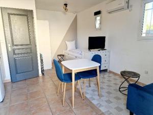 ein Wohnzimmer mit einem Tisch, Stühlen und einem Bett in der Unterkunft Studio Beau Soleil in LʼIsle-sur-la-Sorgue