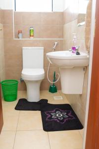 a bathroom with a toilet and a sink at The Royals in Tatu City