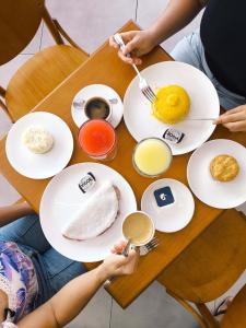 deux personnes assises à une table avec des assiettes de nourriture dans l'établissement Luxo à beira-mar com Café no Solar Tambaú, à João Pessoa