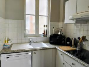 a kitchen counter with a sink and a window at Emplacement exceptionnel Appartement très lumineux au cœur de Cabourg in Cabourg