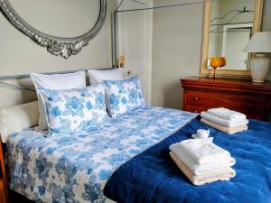 a blue and white bed with towels and a mirror at Emplacement exceptionnel Appartement très lumineux au cœur de Cabourg in Cabourg