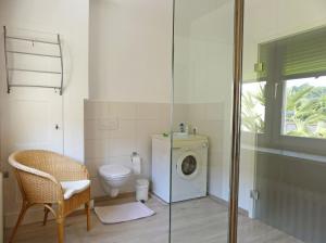a bathroom with a washing machine and a toilet at Margaretes Gästehaus - Ferienwohnung am Rheinsteig in Rheinbrohl +18 photos