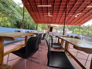 a row of tables and chairs in a restaurant at Mantan Stay in Tadri +22 photos