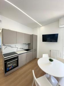 una cucina bianca con un tavolo e una sala da pranzo bianca di Lanterna View Apartment - Sea View a Genova