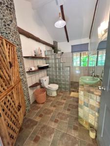 a bathroom with a toilet and a sink at Cabanas Los Colibris Hotel Ecolodge in San Carlos
