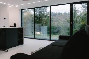 a living room with a couch and large windows at Oxygen Resort Cabin Hotels Lacu Rosu in Lacu Roşu