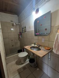 a bathroom with a sink and a toilet and a mirror at Guavirá cabañas and rooms in Puerto Iguazú