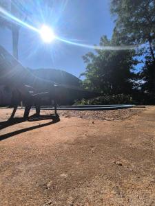 a person sitting on a bench in the sun at Guavirá cabañas and rooms in Puerto Iguazú