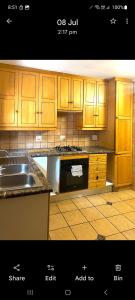 a kitchen with wooden cabinets and a sink at Villa La Maison in Pretoria
