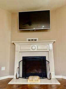 a fireplace with a flat screen tv above it at Your Lawrenceville home in the heart of it all in Lawrenceville