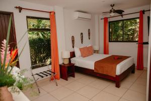 a bedroom with a bed and two windows at Eco Boutique Hotel Vista Las Islas Reserva Natural in Paquera