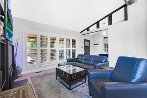 Cozy Bungalow - 5mins to The Ottawa Hospital في أوتاوا: غرفة معيشة مع كرسيين أزرقين وطاولة