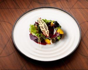 a white plate with a salad on a table at EPIC SANA Algarve Hotel in Albufeira +43 photos