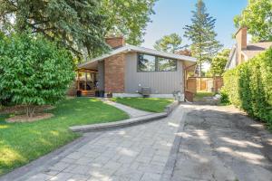 Cozy Bungalow - 5mins to The Ottawa Hospital في أوتاوا: منزل فيه ممشى امام ساحة