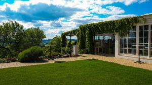 une maison avec une véranda couverte de lierre avec une pelouse dans l'établissement Hotel Golden Key, 4 Stars Superior, à Nitra
