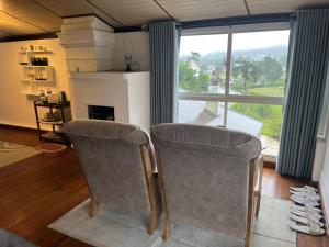 a living room with two chairs and a fireplace at Medalin Harmony Heaven in Nuwara Eliya