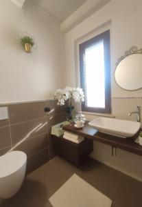 a bathroom with a sink and a toilet and a mirror at La Casa Di Stefania in Pollutri