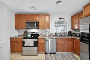 a kitchen with wooden cabinets and stainless steel appliances at Happy Days at Two Oaks 4BD Home Minutes From Beautiful Lake Hollingsworth in Lakeland