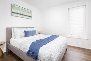 een slaapkamer met een bed met een blauwe deken erop bij Charming 3 Beds Ossington Home in Toronto