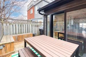een patio met een houten tafel en een bank bij Charming 3 Beds Ossington Home in Toronto