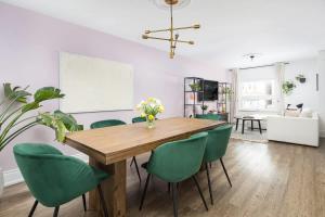 een eetkamer met een houten tafel en groene stoelen bij Charming 3 Beds Ossington Home in Toronto