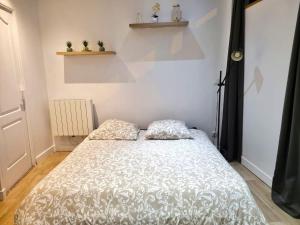 a bedroom with a bed with two pillows on it at Studio avec terrasse in Elbeuf