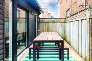 een houten tafel op een balkon met een houten hek bij Charming 3 Beds Ossington Home in Toronto +25 foto's