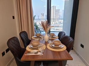 アブダビにあるElegant Pool-View 1BR Near Cleveland Clinicのダイニングテーブルと椅子、そして大きな窓
