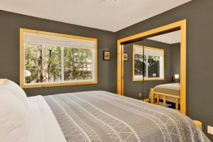 a bedroom with a large bed and two windows at Country Club Cabin #357 in Big Bear City