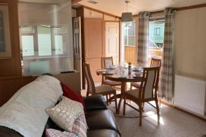 a living room with a table and a couch at 2 Bed Caravan - Sleeps 6 - Pets - River Teviot in Hawick
