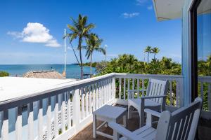 a balcony with two chairs and a view of the ocean at Conch Key Fishing Lodge & Marina in Conch Key
