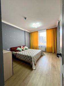 a bedroom with a bed and a large window at Современный 3х комнатный апартаменты на Туране возле Барыс Арена in Astana +4 photos