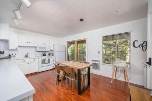 una cocina con armarios blancos y una mesa y sillas de madera. en Ski-in ski-out Condo in Brian Head, en Brian Head