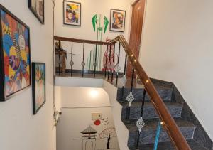 un corridoio con scala con opere d'arte sul muro di The Sheltor a Chennai
