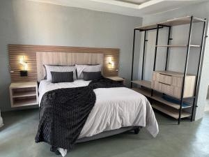 DwarsloopにあるFourteen38 Mews Guesthouseのベッドルーム1室(大型ベッド1台、棚2つ付)