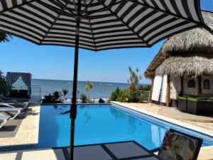 an umbrella sitting on a chair next to a swimming pool at casa del mar in San Rafael del Sur