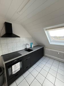 Una pequeña cocina con fregadero y ventana. en Apartment in Wesel Büderich - 6 guests, en Wesel
