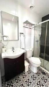 een badkamer met een wastafel, een toilet en een spiegel bij INT Lisbon Suites in Lissabon +14 foto's